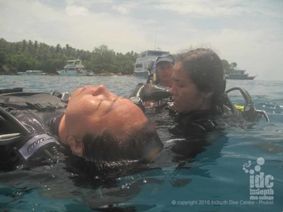 PADI Rescue Diver performing equipment removal on the surface