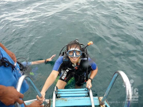 A happy PADI Open Water diver getting back on the boat on Phuket